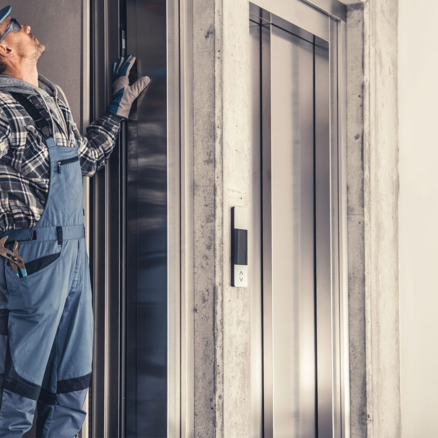 Caucasian Residential Elevator Technician in His 40s Performing Scheduled Maintenance.